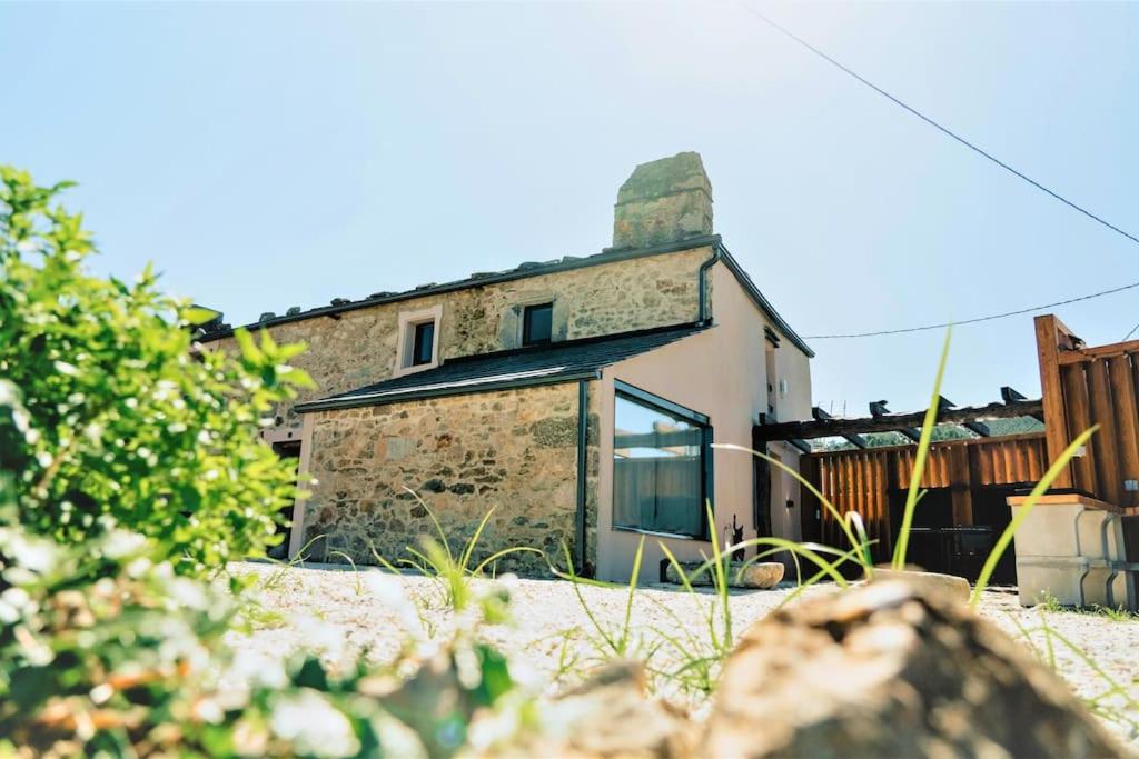 an old stone house in the middle of a yard at O Vicedo Beach Resort WEST in O Vicedo