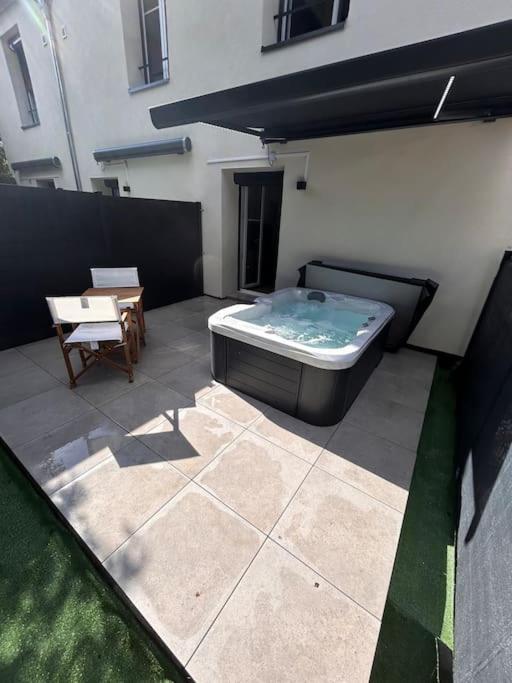 a hot tub sitting on top of a patio at La suite secrète et son spa abrité in Nancy