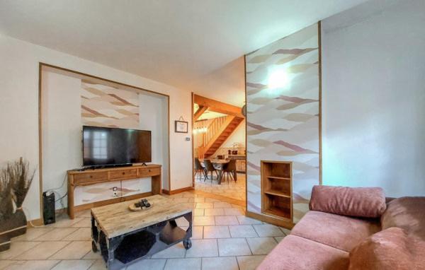 un salon avec un canapé et une télévision à écran plat dans l'établissement Grand gîte chez Gina, à Grand-Fort-Philippe