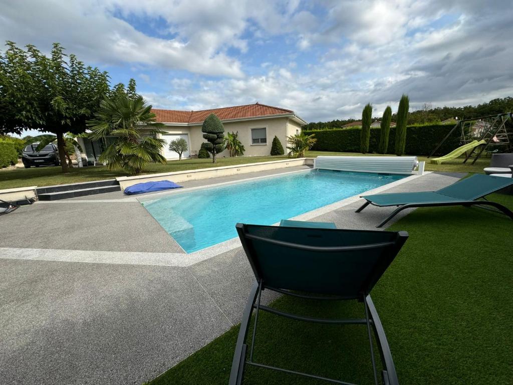 - une piscine avec une chaise et une maison dans l'établissement Villa au pieds du vercors, à Saint-Sauveur