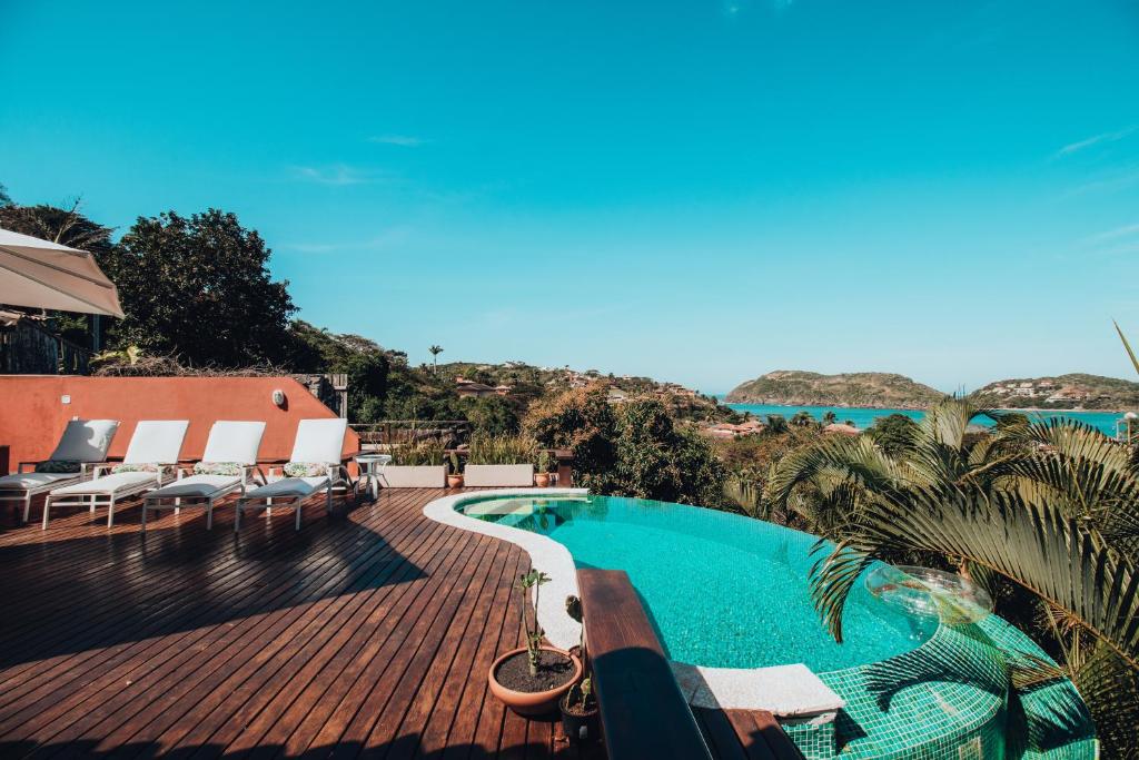 una piscina su una terrazza con vista sull'oceano di Villa Vermelha Ocean View a Búzios