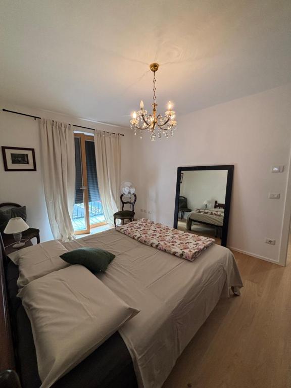 a bedroom with a bed with a mirror and a chandelier at Casa delle Orchidee in Feltre
