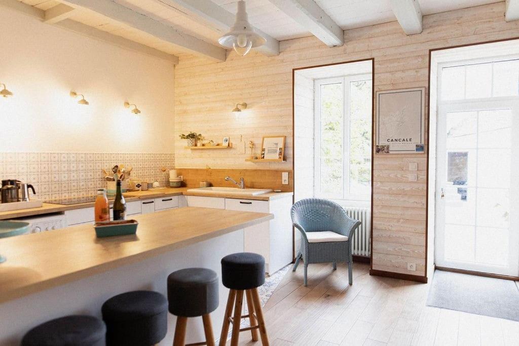 - une cuisine avec un comptoir et quelques chaises dans l'établissement cancaleloca, à Cancale