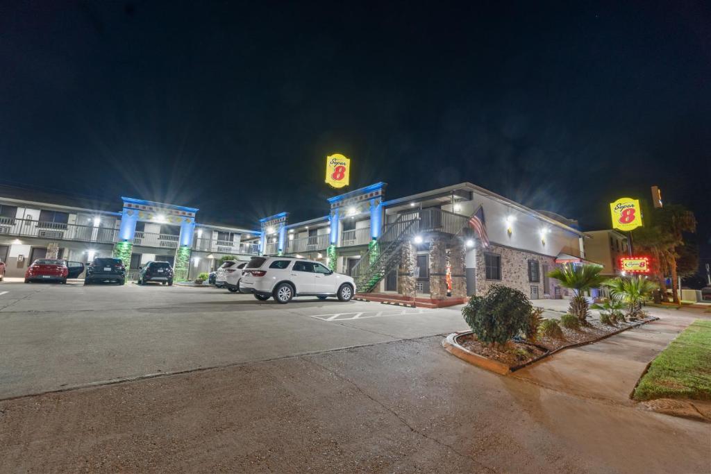 a parking lot in front of a hotel at night at Super 8 by Wyndham McAllen-Downtown-Airport-LA Plaza Mall in McAllen