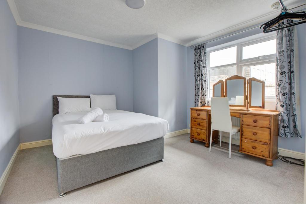 a bedroom with a bed and a dresser and a mirror at The Sandringham Court Hotel & Apartment Welcoming Large and Small Groups for 15 years in Blackpool