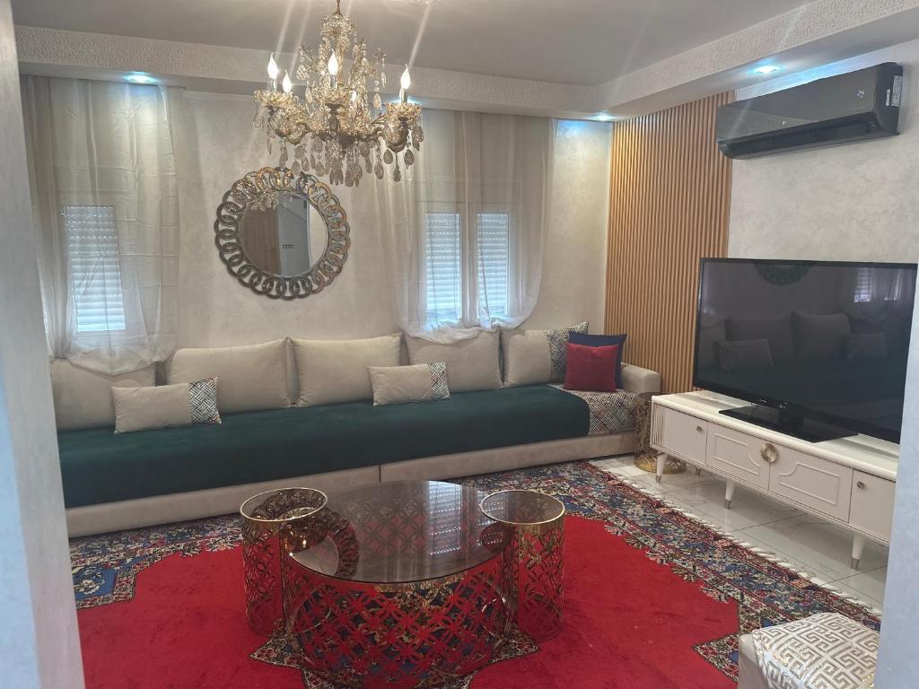 een woonkamer met een bank en een televisie bij Riad Jad - Sweet Duplex Appartement in Marrakesh