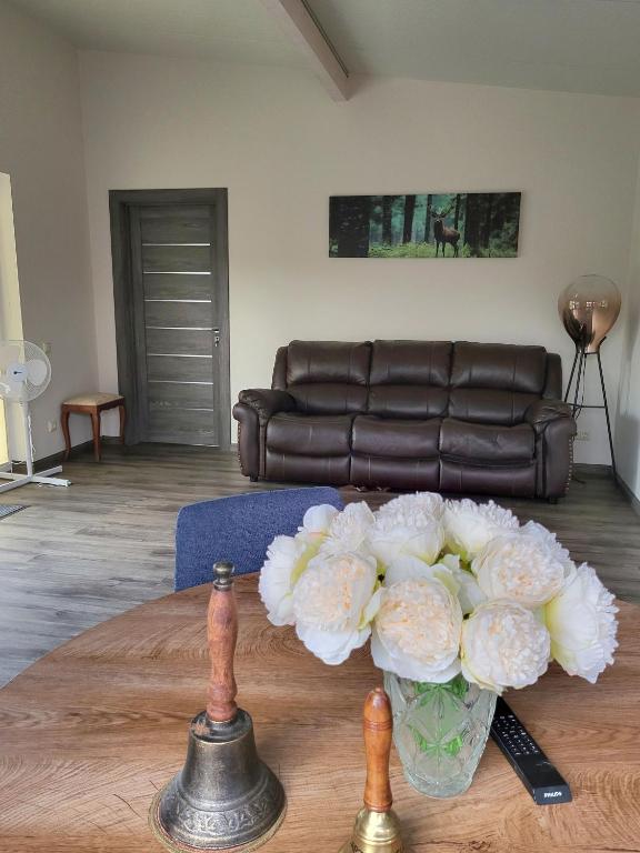 a vase of flowers on a table in a living room at River Apartment in Līči