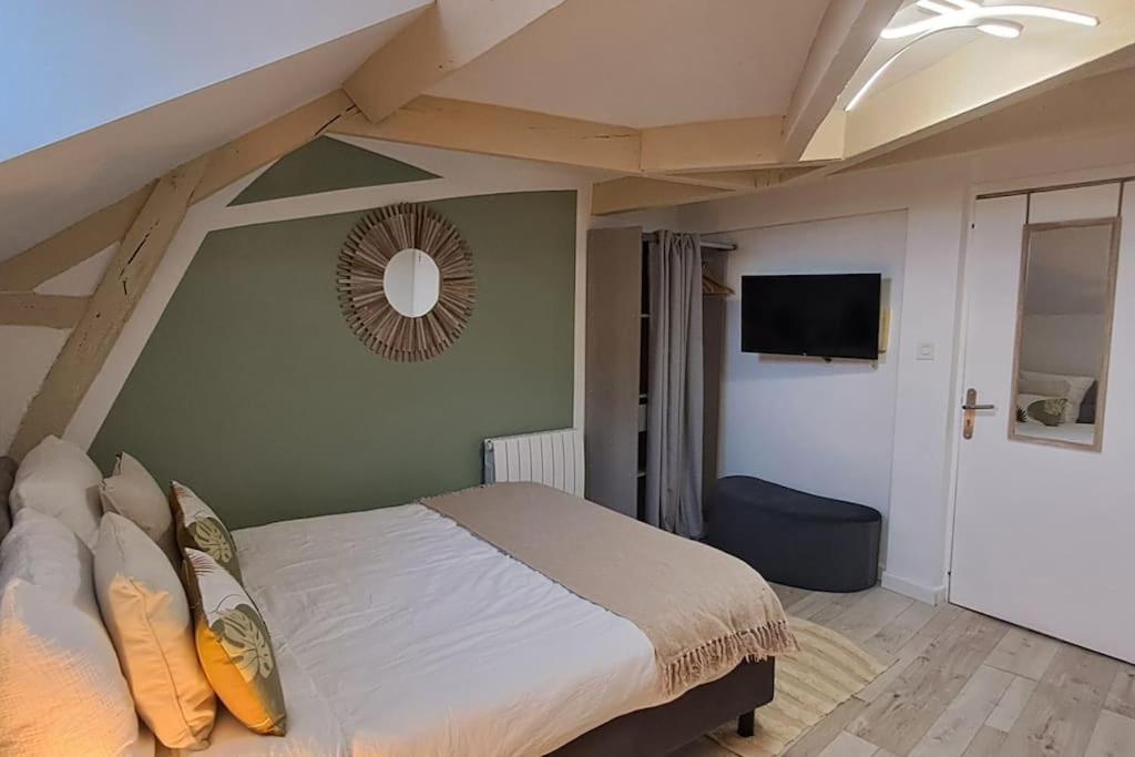 Un dormitorio con una cama y un televisor de pantalla plana. en Studio NOTRE-DAME 3 cœur de ville, en Cholet