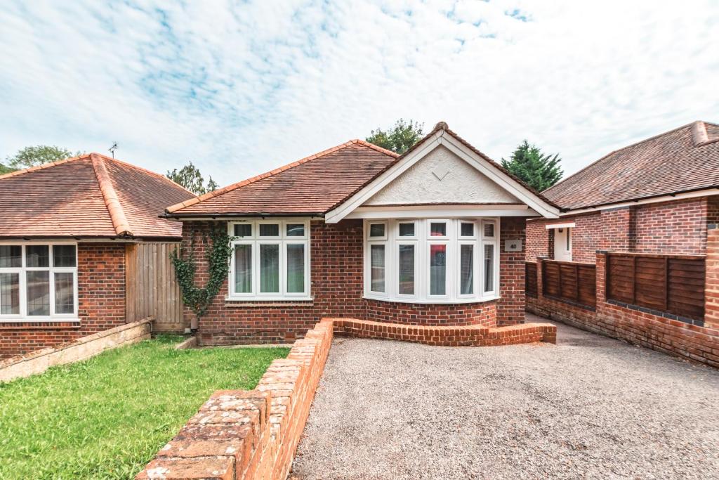 ein Backsteinhaus mit einer Einfahrt davor in der Unterkunft Family Gathering Bungalow in Southampton