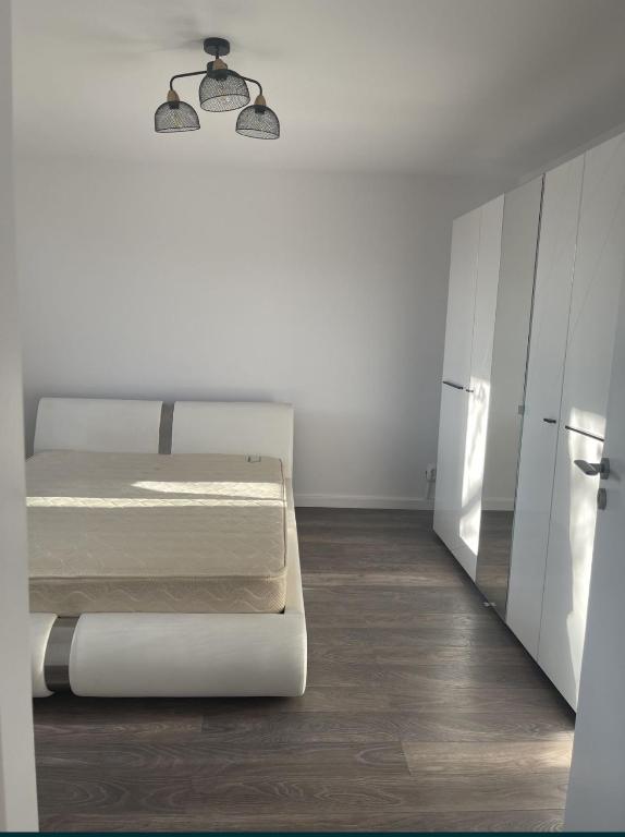 a white bedroom with a bed and a mirror at Casa 3 camere, NU MAI ESTE DISPONIBILA, NO AVAILABLE in Dumbrăviţa