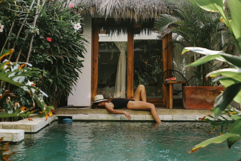 a woman laying on the edge of a swimming pool at Casa Areka in Brisas de Zicatela