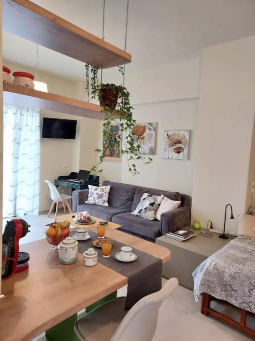 アテネにあるSunny studio near metroのソファとテーブルのあるリビングルーム