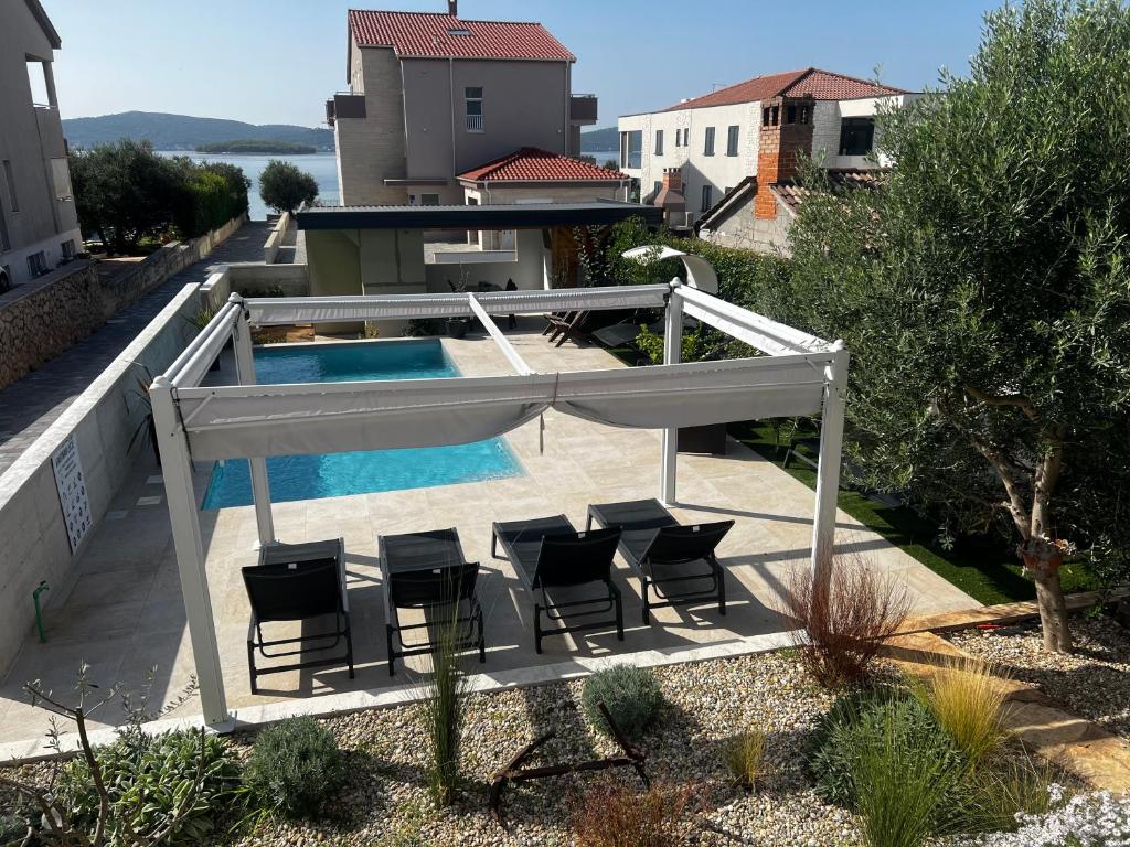 a patio with chairs and a swimming pool at Apartment Lucie3 in Biograd na Moru