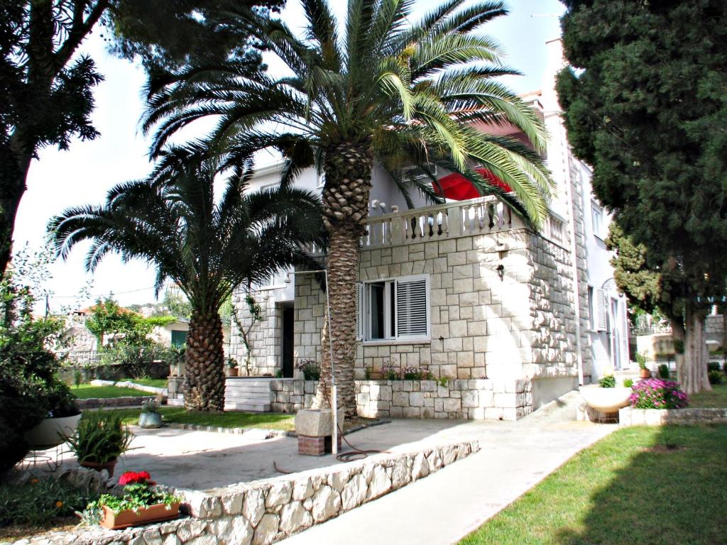 a building with two palm trees in front of it at Holiday Home Nena in Trogir