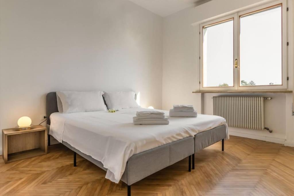 una camera bianca con un grande letto e due finestre di Tofane sky loft a Treviso