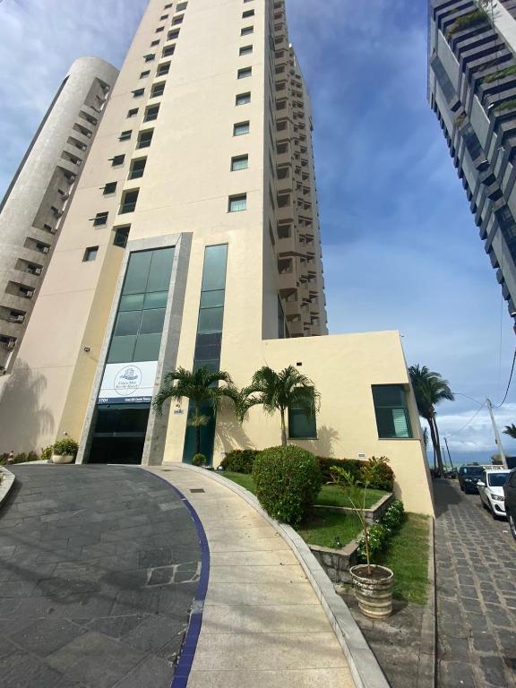 a tall building with a walkway in front of it at Flat Beira Mar Piedade 1603 in Recife