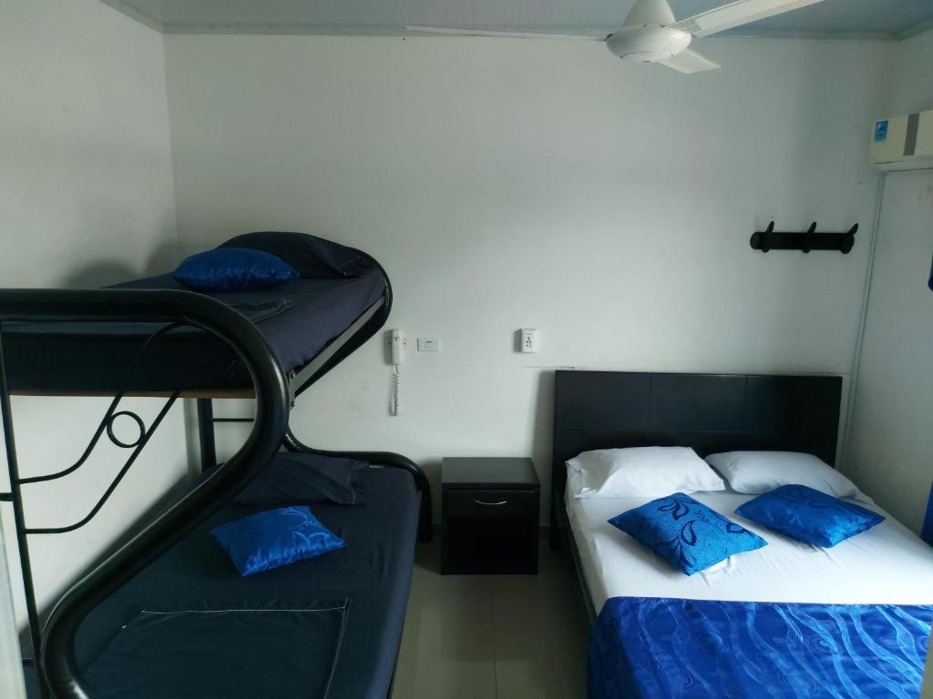a bedroom with two bunk beds with blue pillows at Hotel Perla Azul Boutique in Girardot