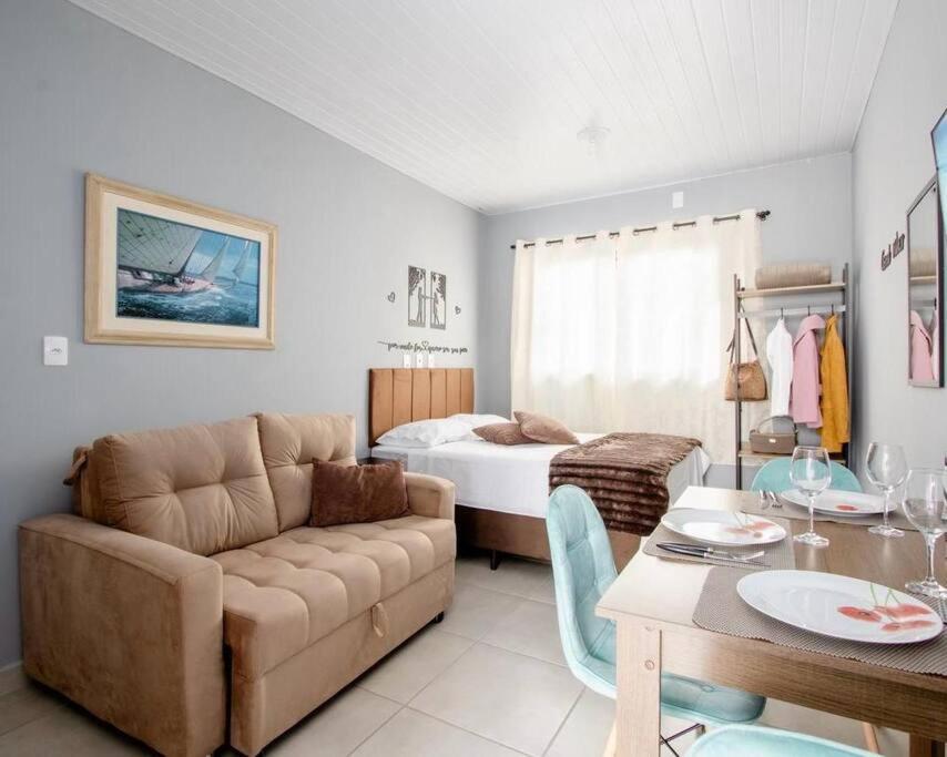 un salon avec un canapé et un lit dans l'établissement Studio 3 - Linda vista beira-mar, à Florianópolis