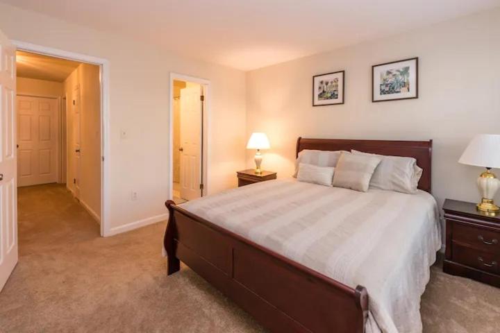 a bedroom with a large bed and two lamps on tables at 3 Bedroom Townhouse 8 Miles to Washington DC in Falls Church