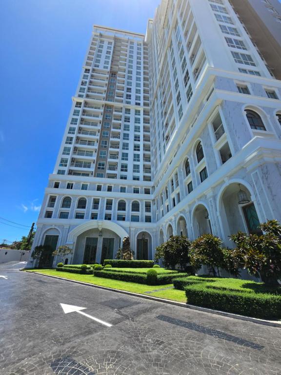 ジョムティエンビーチにあるThe Empire Tower Pattaya, Jomtien Beachの道路の前にある大きな白い建物