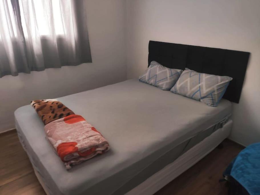 un letto con due cuscini sopra di apartamento no paraiso a Ponte Nova