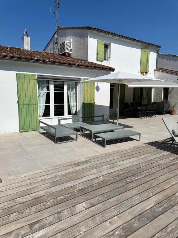 - une terrasse avec 2 tables de pique-nique et un parasol dans l'établissement Le pin maritime, à Ars-en-Ré