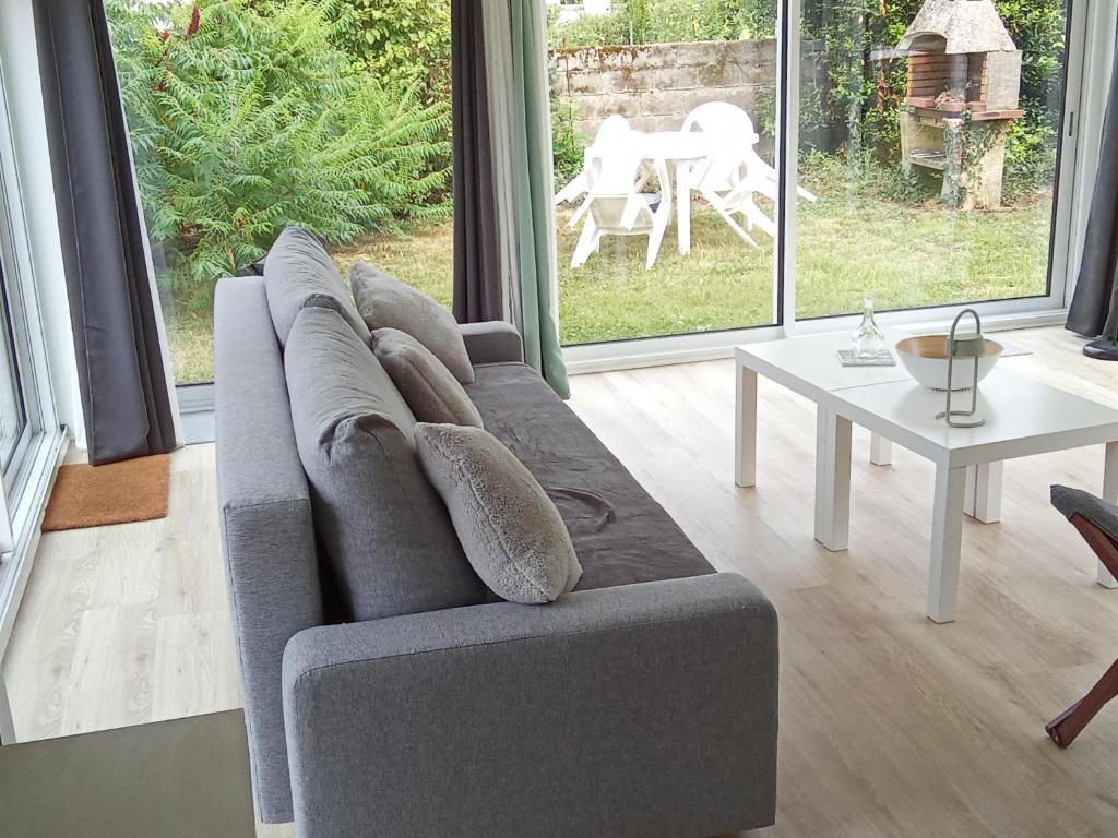 un salon avec un canapé gris et une table dans l'établissement Charmant loft avec jardin près du centre ville, à Amboise