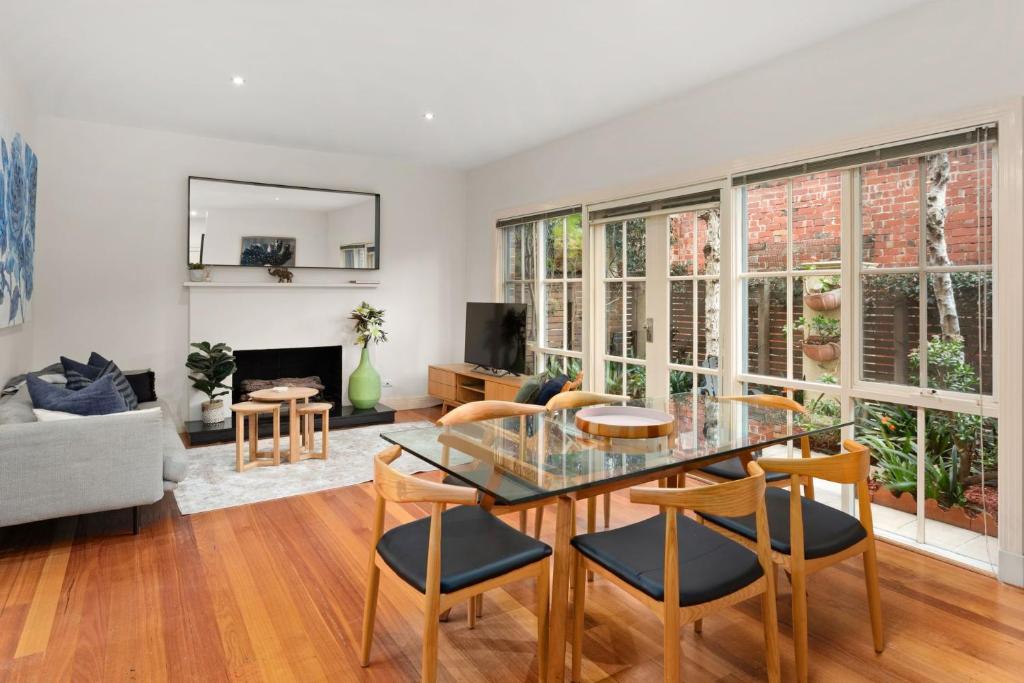 Una sala de estar con una mesa de cristal y sillas. en Boutique Stays - Brighton Abode, en Melbourne