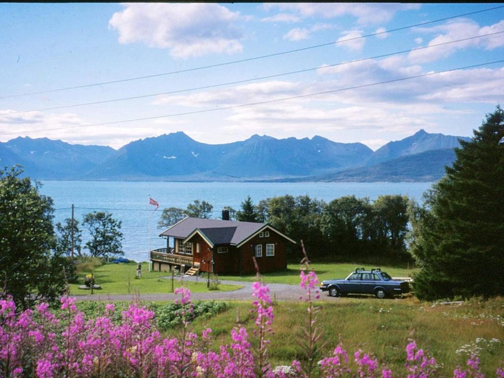 a house and a car parked in front of a lake at 6 person holiday home in BORKENES-By Traum in Harstad