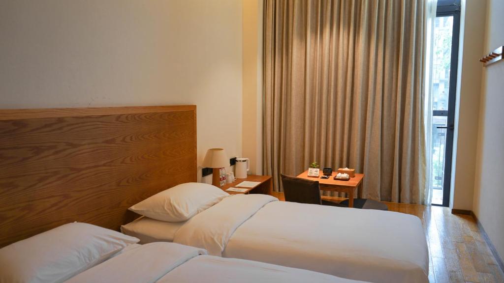 Postel nebo postele na pokoji v ubytování Taihua Wutong Hotel