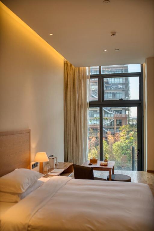 Postel nebo postele na pokoji v ubytování Taihua Wutong Hotel