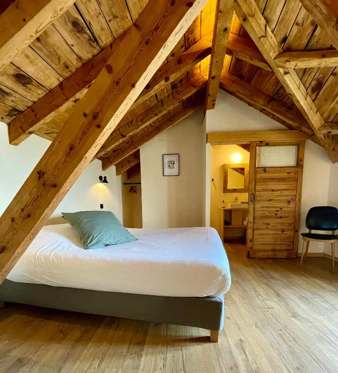une chambre avec un grand lit dans un grenier dans l'établissement Domaine Agricole Cotzé / Casa rural, à Enveitg