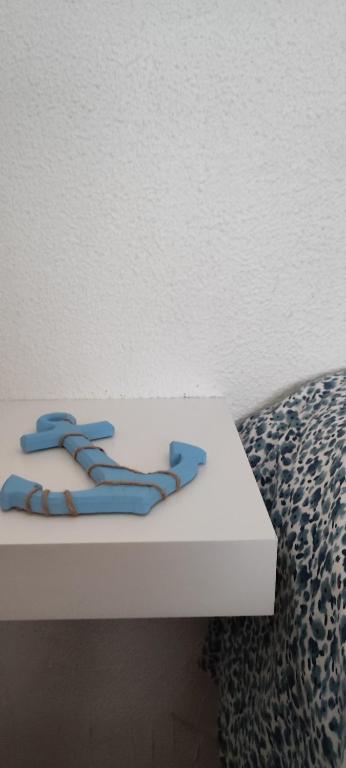 a white table with blue handles next to a bed at Casa da Tia in Ferrel