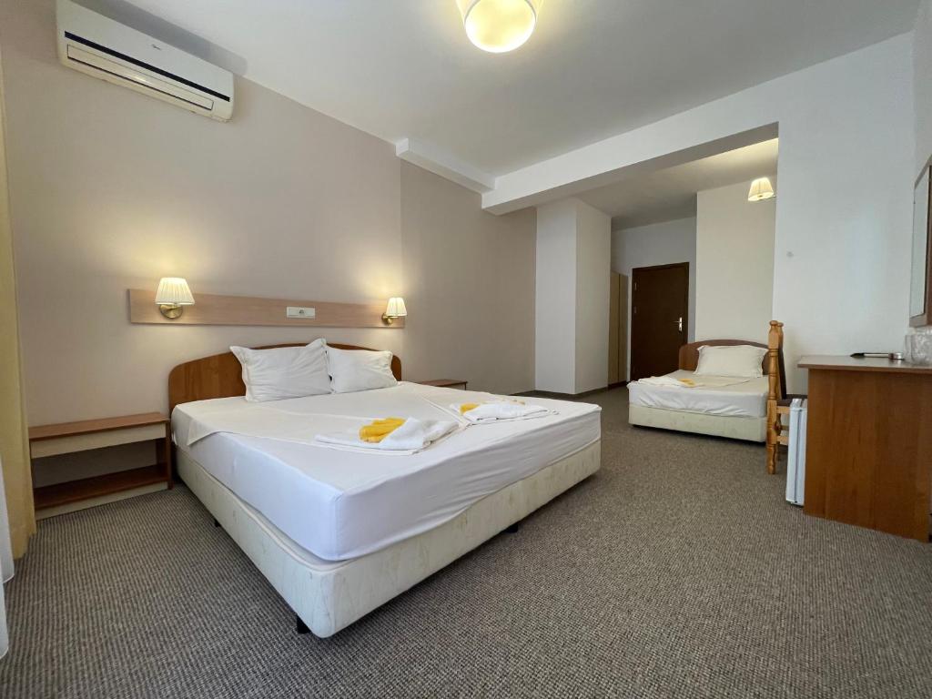 a hotel room with a large white bed in it at Alatoni Beach Hotel in Sozopol