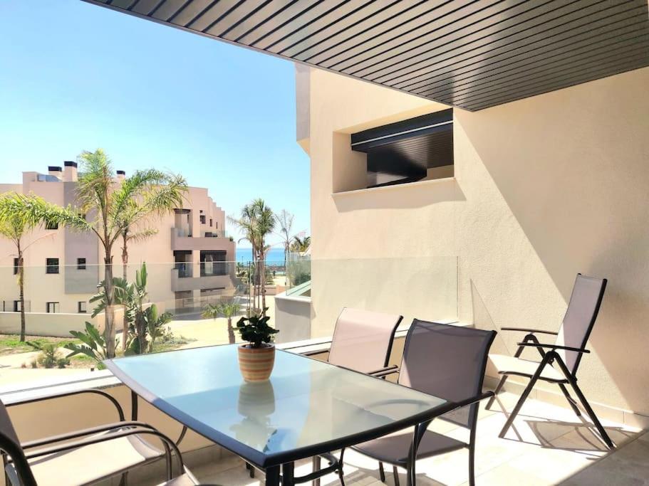 マラガにある1º Línea de playa con piscina panorámica & parkingの建物の景色を望むバルコニー(テーブル、椅子付)