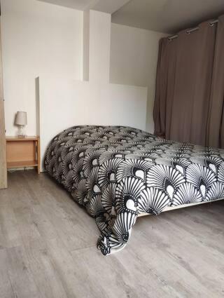 une chambre avec un lit avec une couverture dessus dans l'établissement Suite parentale indépendante avec accès direct jardin, à Sotteville-lès-Rouen