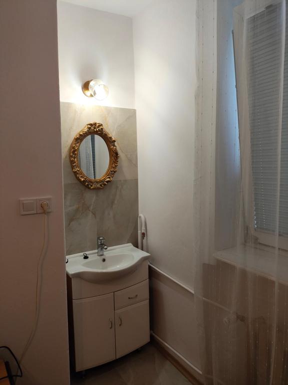 a bathroom with a sink and a mirror at Baza Noclegowa ARKADIA in Świnoujście