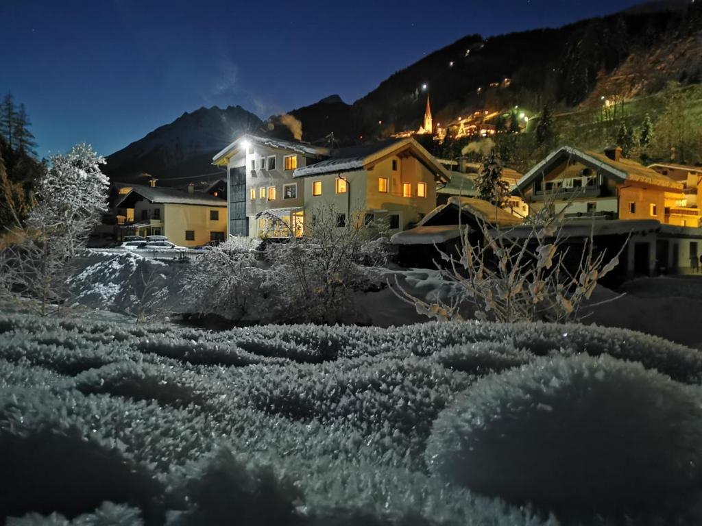 un villaggio di notte con neve sul terreno di Hotel Garni DIAS a Kappl