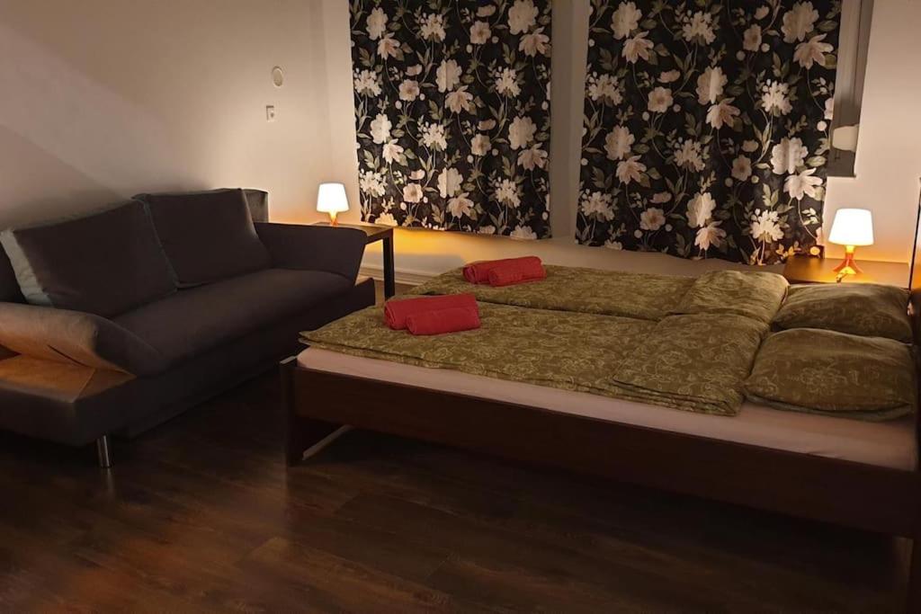 a bed and a couch in a living room at Apartament w Welskiej Kamienicy in Lidzbark