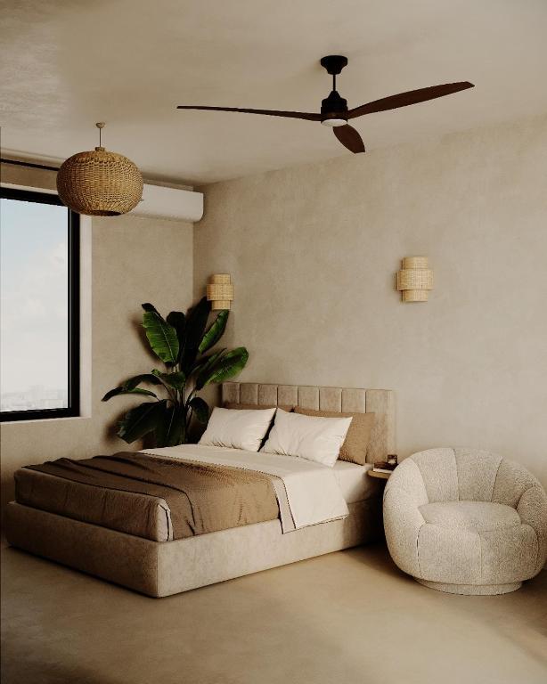 a bedroom with a bed and a fan and a chair at SLEEP INN - Kyoto Suites South Antwerp in Antwerp