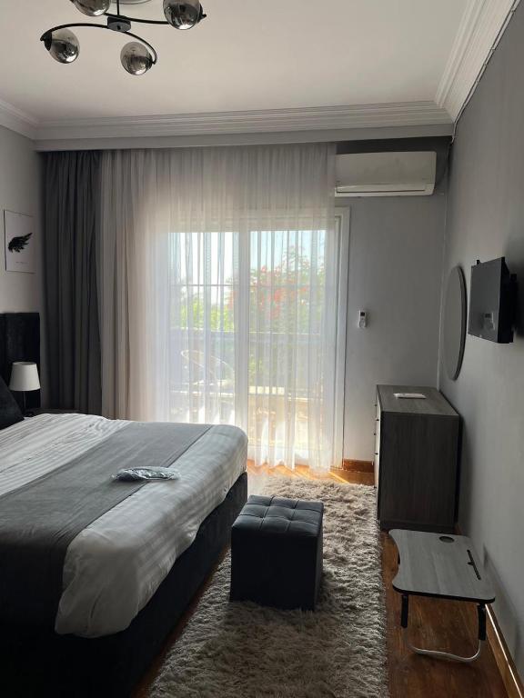 a bedroom with a bed and a large window at Madinty vg1 مجموعة ٨ فيلا ٤١ مدينتى فرش فندقى بلكامل in Madinaty