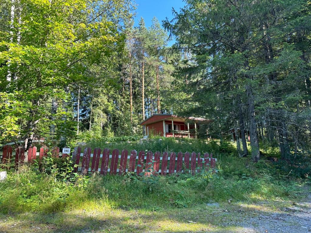 a house in the woods behind a fence at Villa vappu in Kuopio