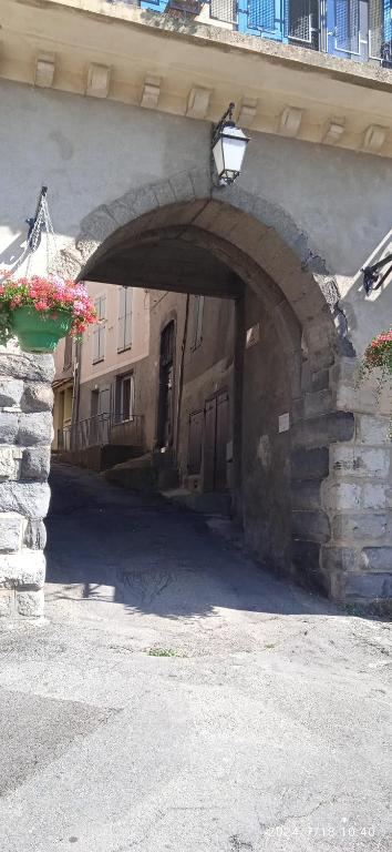 une arche dans un bâtiment avec des fleurs dans un pot dans l'établissement Appartement, à Seyne