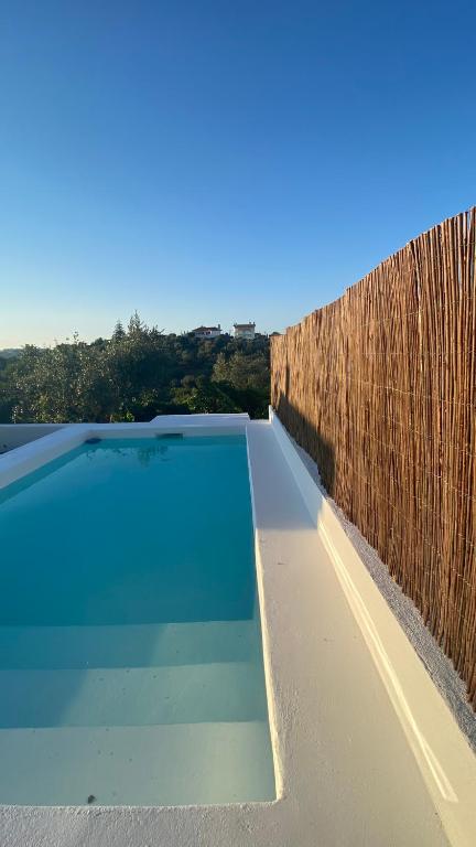 a swimming pool next to a wooden fence at A casa dos avós in Abrantes