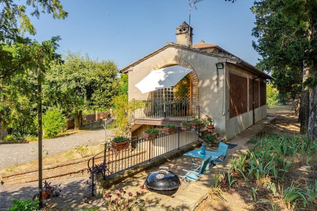 a small house with a balcony and a fence at Oasi in the garden Cozy home - Perugia in Perugia
