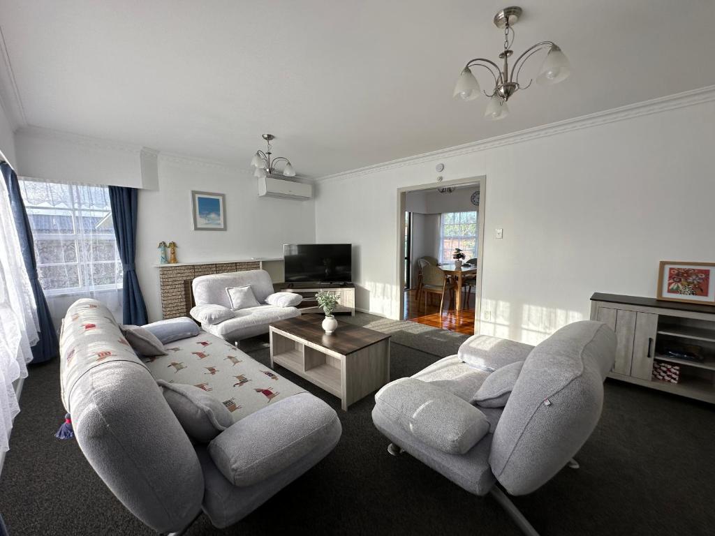 ハミルトンにあるGracious 3 Bdrm House in Chartwellのソファと椅子とテーブルのあるリビングルーム