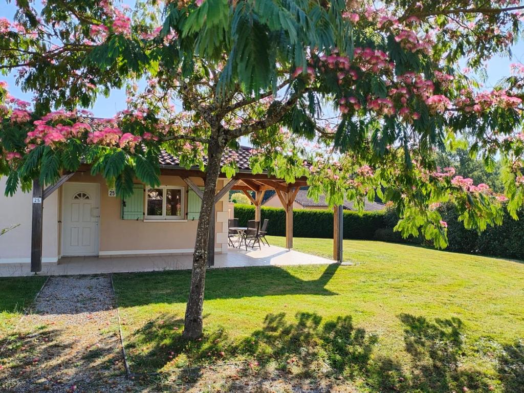 a house with a tree with pink flowers at French Country Villas in Les Forges