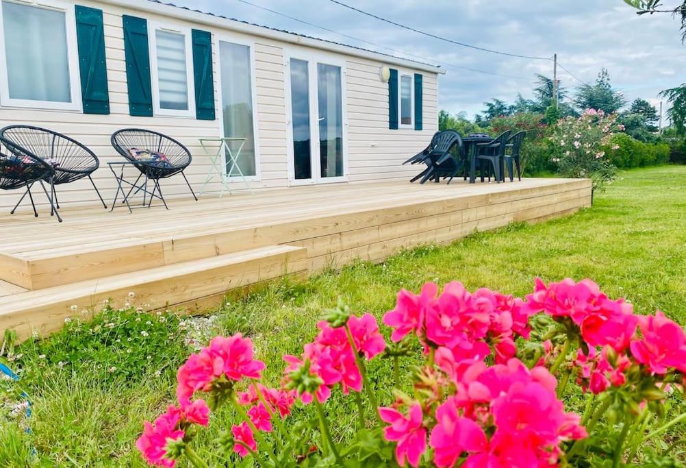 ein Haus mit einer Terrasse mit Stühlen und rosa Blumen in der Unterkunft Nuit ou week end nature 6 pers TT équipé in Messimy
