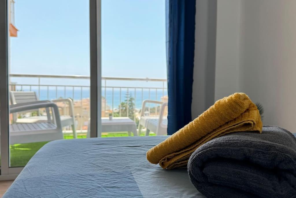 a yellow towel sitting on top of a bed in a room at Sea views from the bed Design studio in Torrox