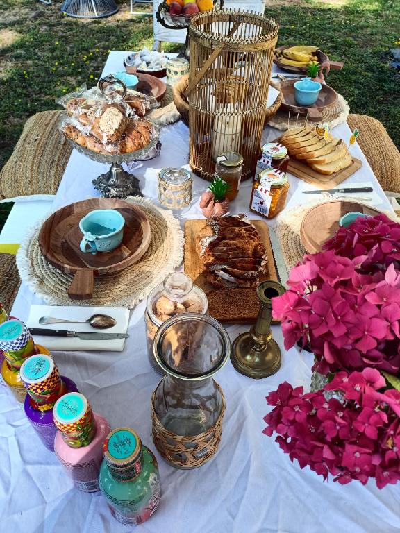 une table avec de la nourriture et des fleurs en haut dans l'établissement Chez Célia Bed&Breakfast, à Champdeniers